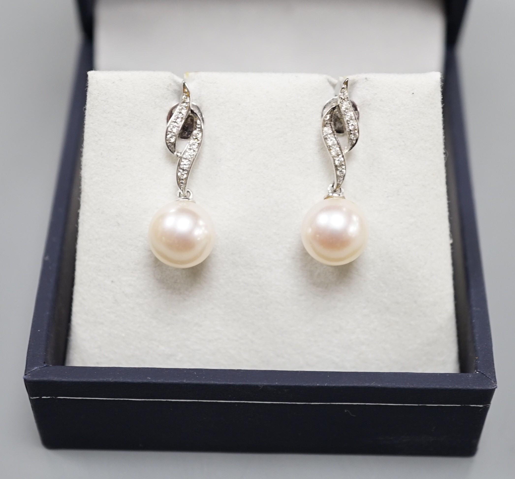 A modern pair of 14k white metal, cultured pearl and diamond set drop earrings, 24mm, gross weight 3.8 grams.